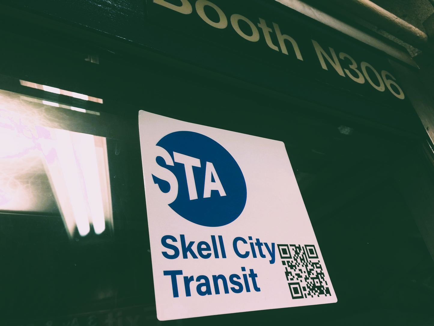 Skell City Station sticker attached to window of MTA transit worker booth.