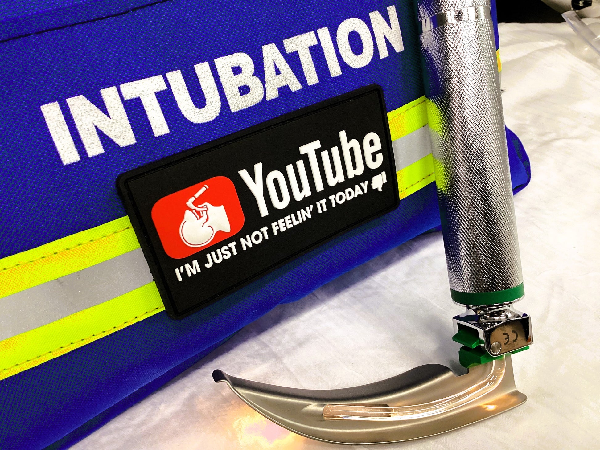 YouTube, I'm just not feelin' it today, PVC patch attached to an intubation kit, next to a laryngoscope blade.