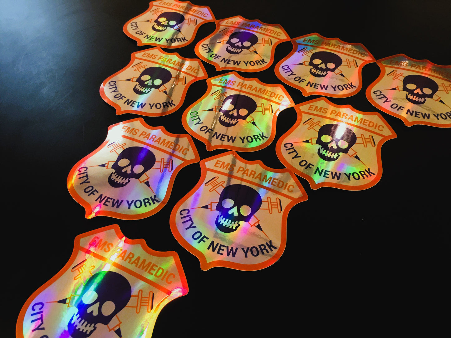 NYC EMS Paramedic patch holographic stickers from skellcity on a black background in pyramid set up.