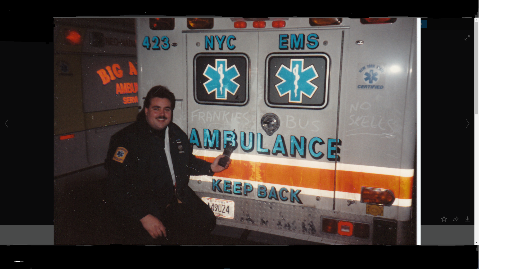 EMT Frankie the Fish smiling while holding an old brick radio pointing at the back of his NYC EMS ambulance where 'frankies bus,no skells' is written in dust