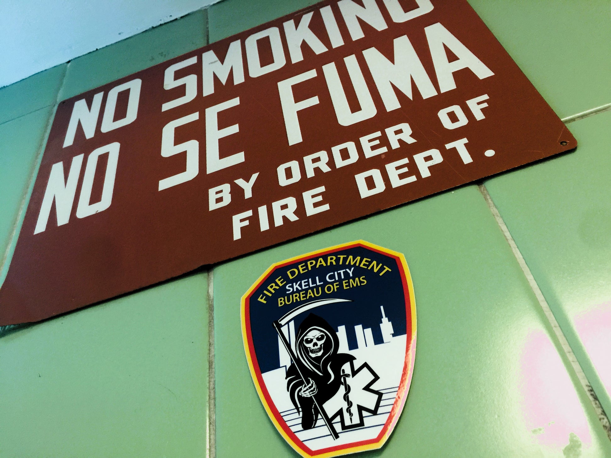 FDNY Fire Department Bureau Of EMS sticker, from skell city, up against hospital wall. Next to a No Smoking Sign.