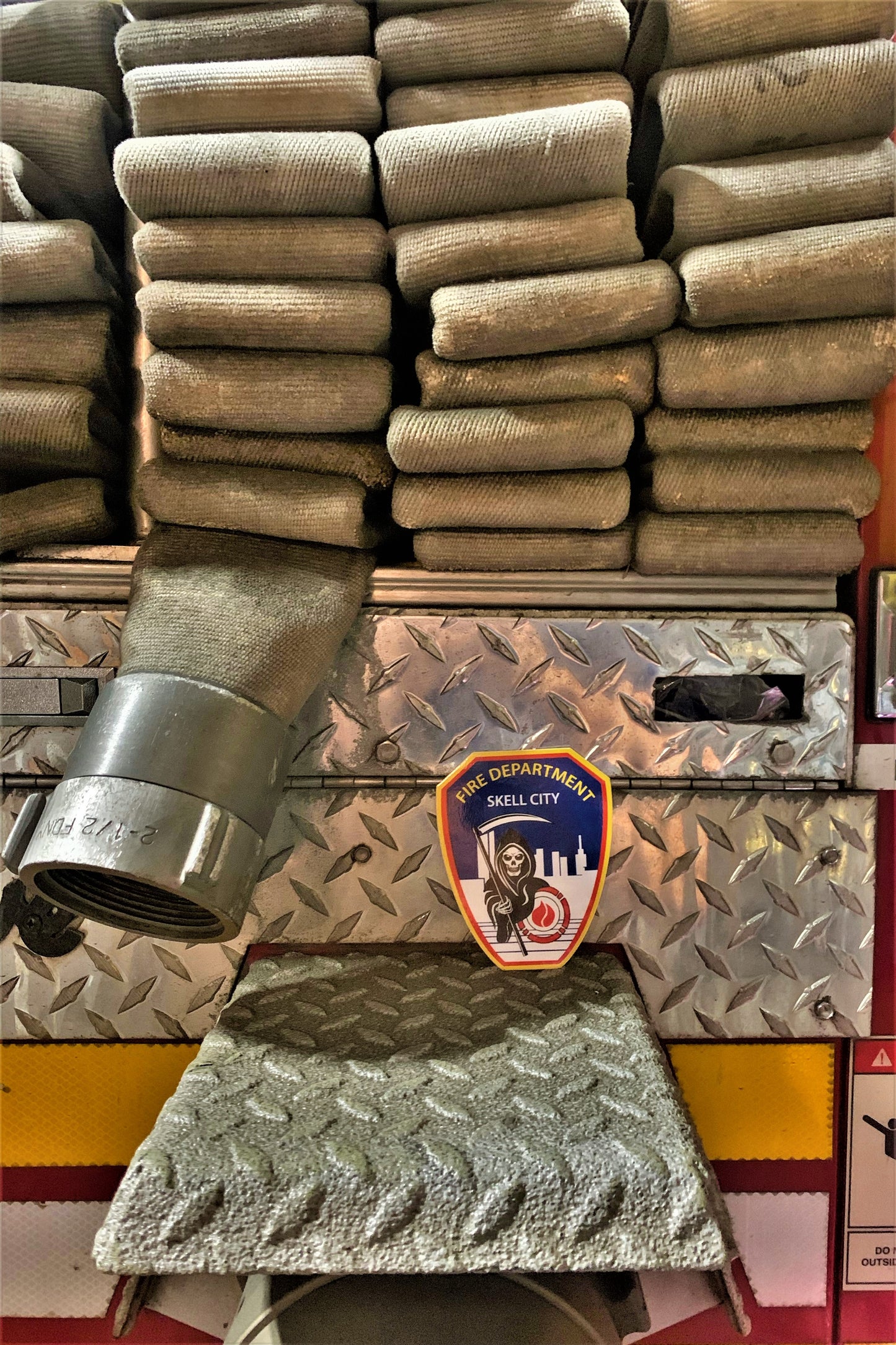 FDNY skell city sticker posted up against fire engine hose bed.