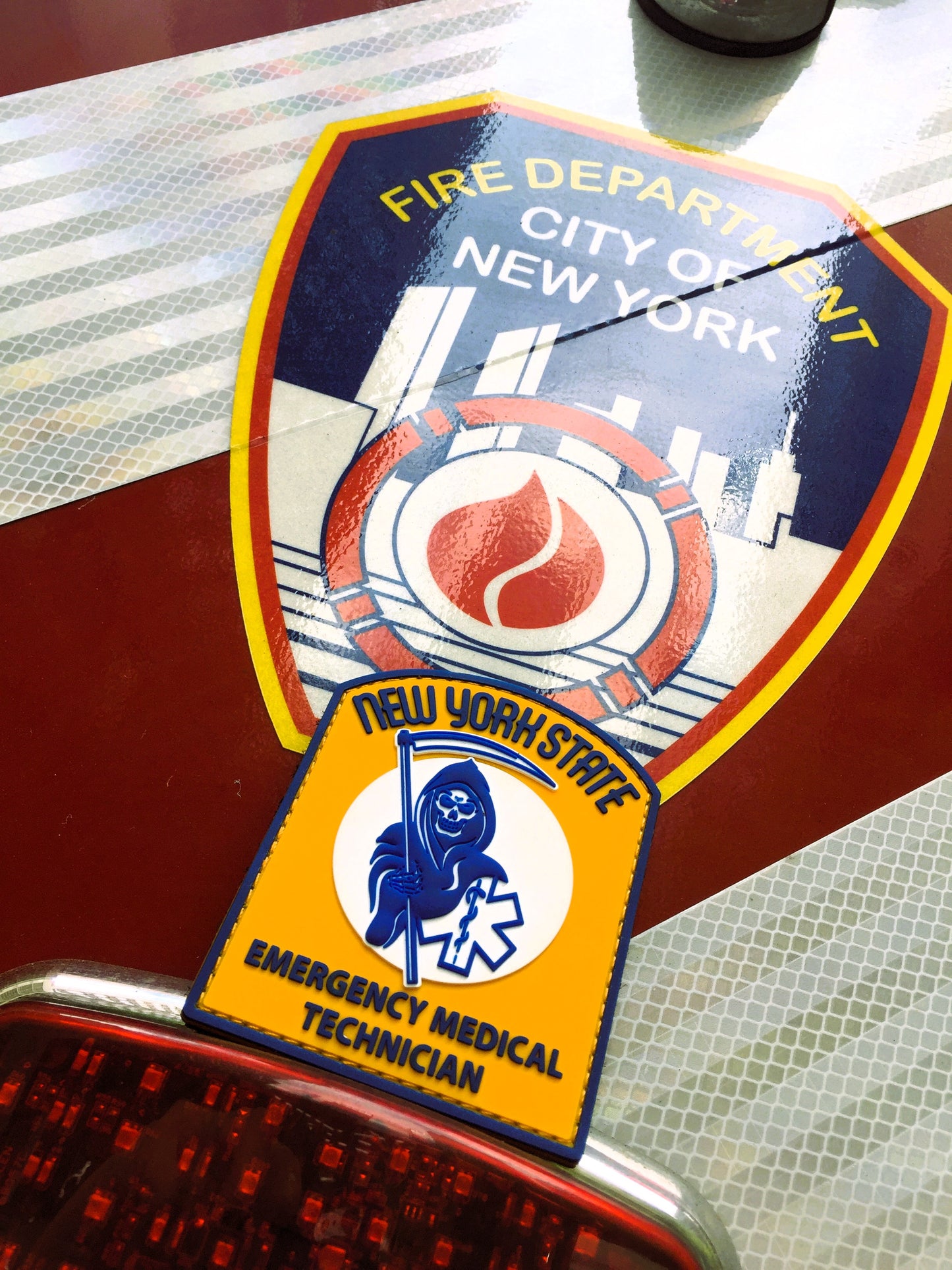 new york state skell city reaper EMT Velcro PVC patch up against the back of FDNY ambulance decal