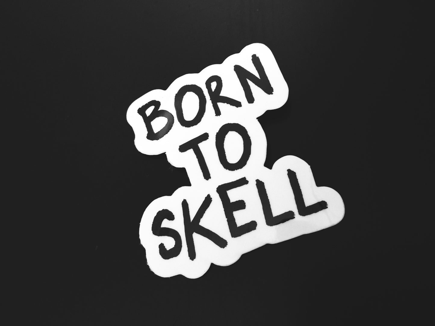 Skell city's Born to Skell clear sticker from skellcity.com against a solid black background.