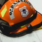 NYC skell city EMS Paramedic patch reflective sticker on the side of an orange ems bunker gear helmet sitting on top of a stretcher.