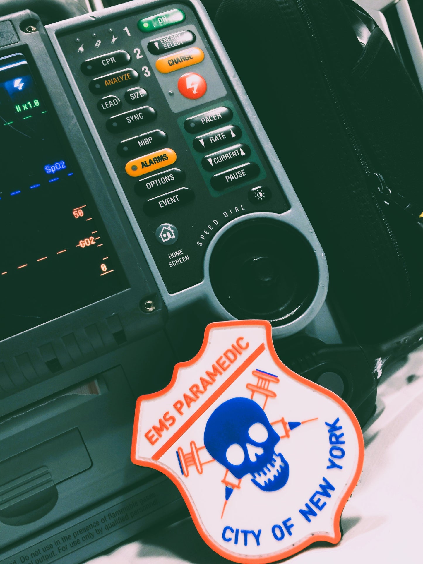 NYC EMS Paramedic patch made of PVC, with a Velcro backing, leaning up against lifepak 15 monitor.