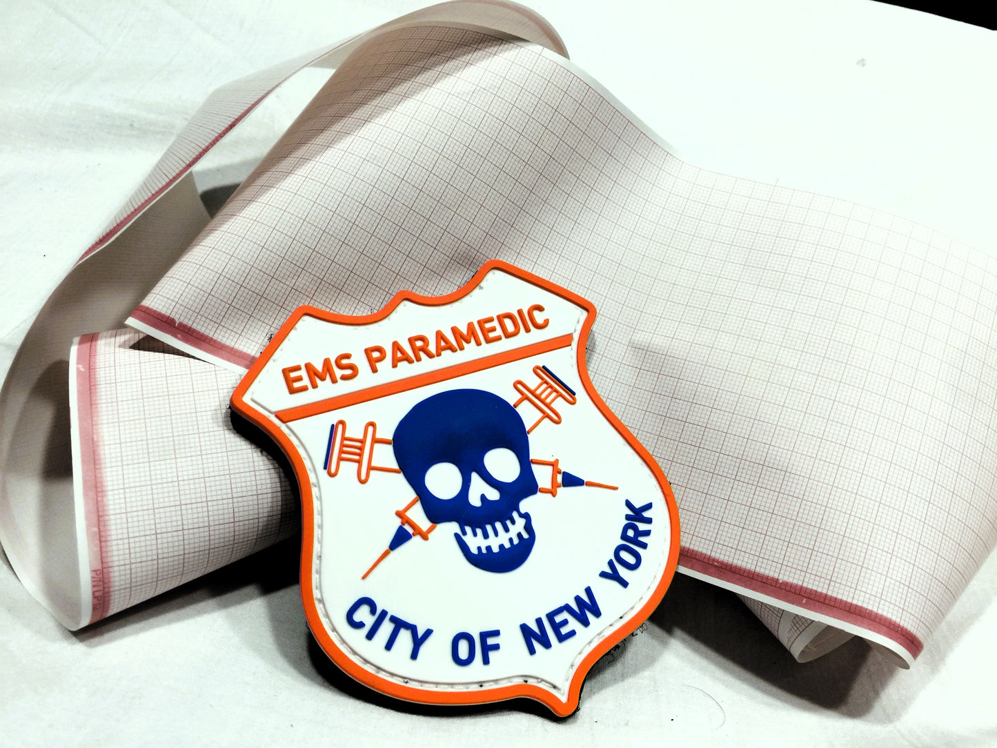 NYC EMS Paramedic patch resting up against randomly coiled EKG paper.