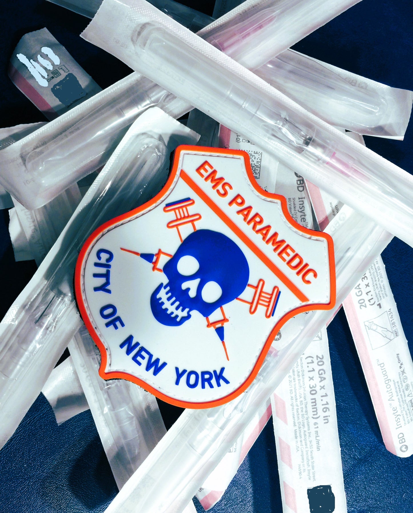 New York City EMS Paramedic patch from skell city sitting on top of bed of IV catheters.