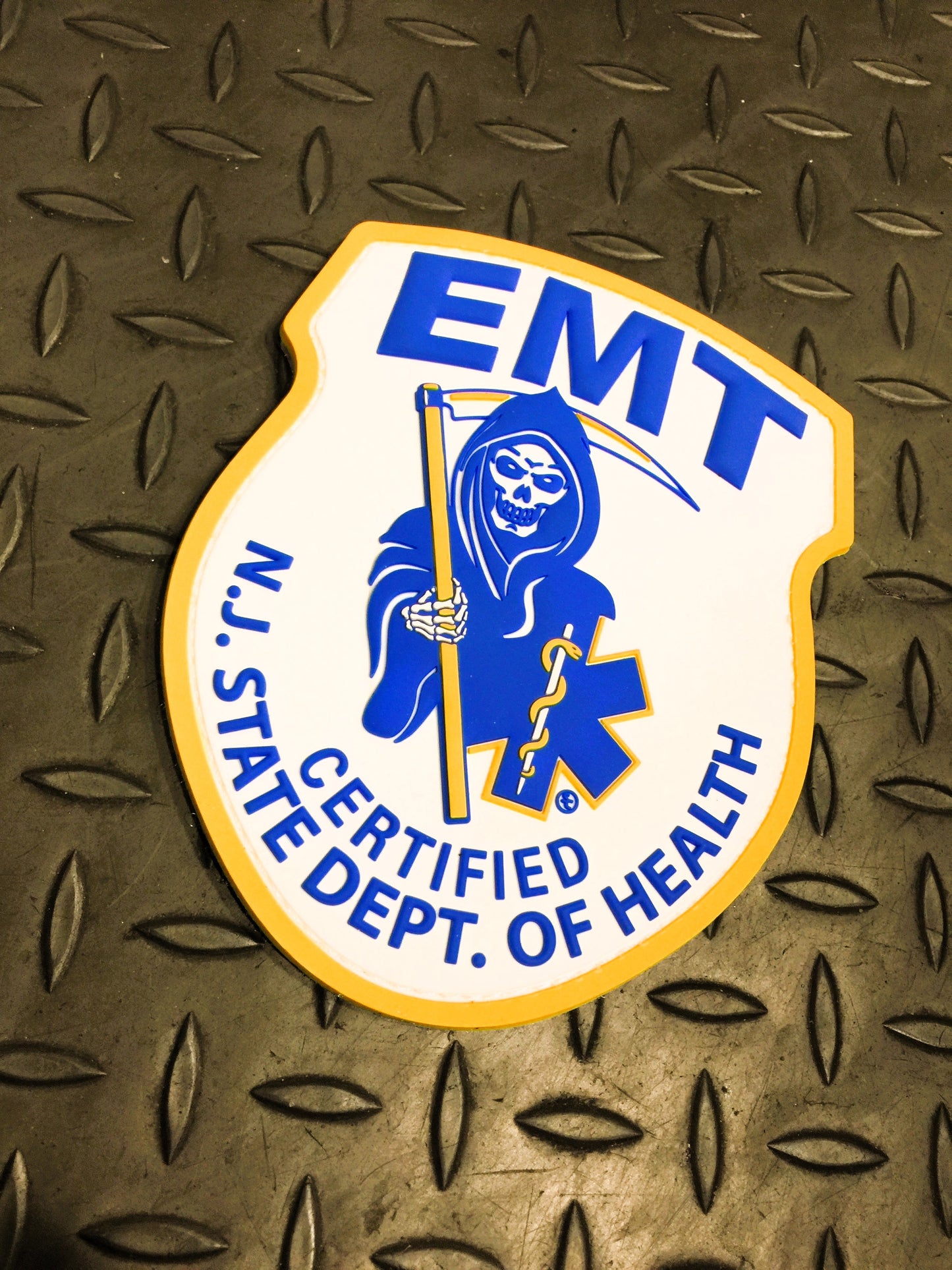 New Jersey EMT PVC Velcro Patch, from Skell City, up against gray gridiron background.