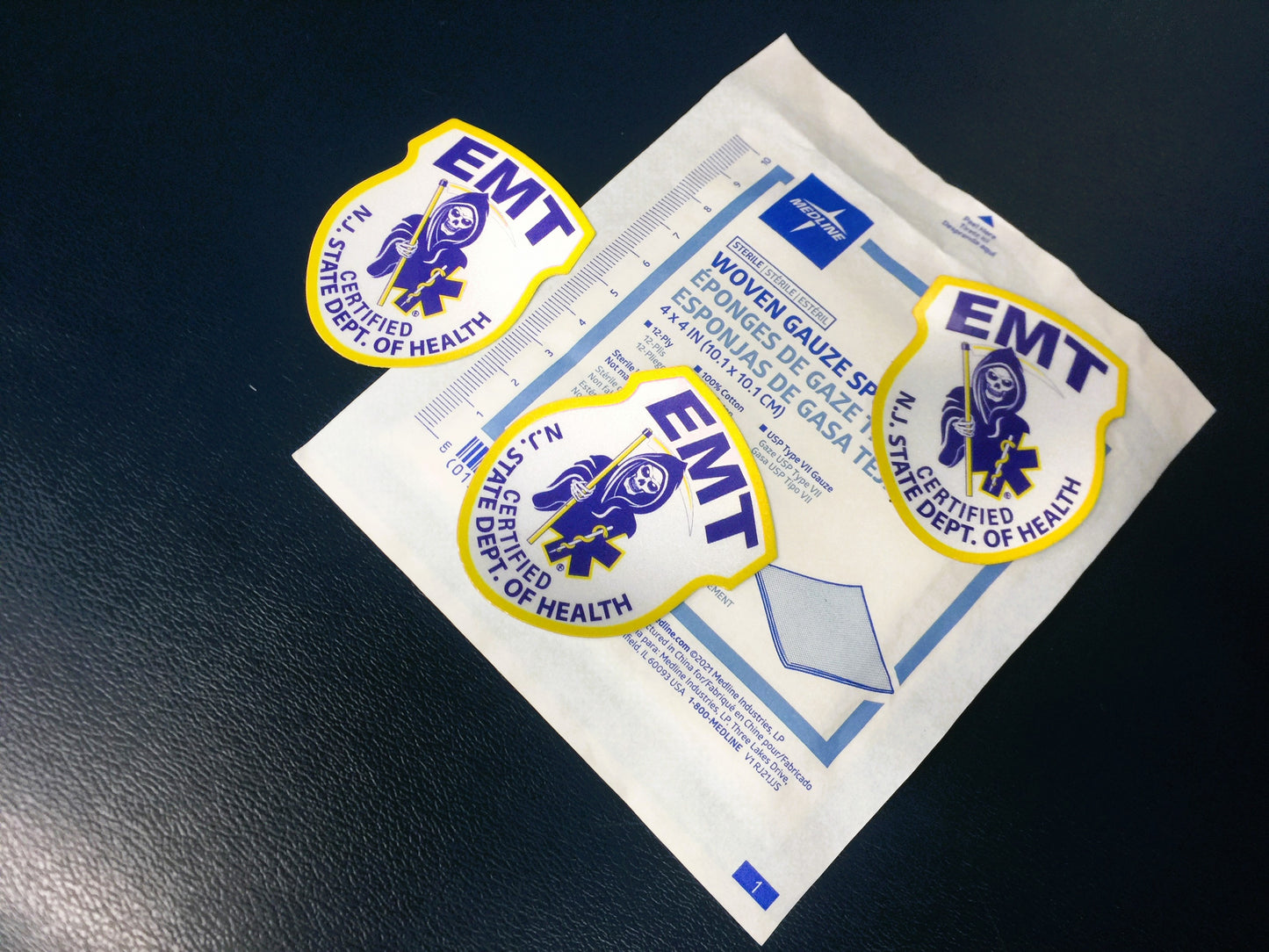 New Jersey EMT patch from skell city Reflective Stickers Lined up against Medline 4x4 gauze packet.