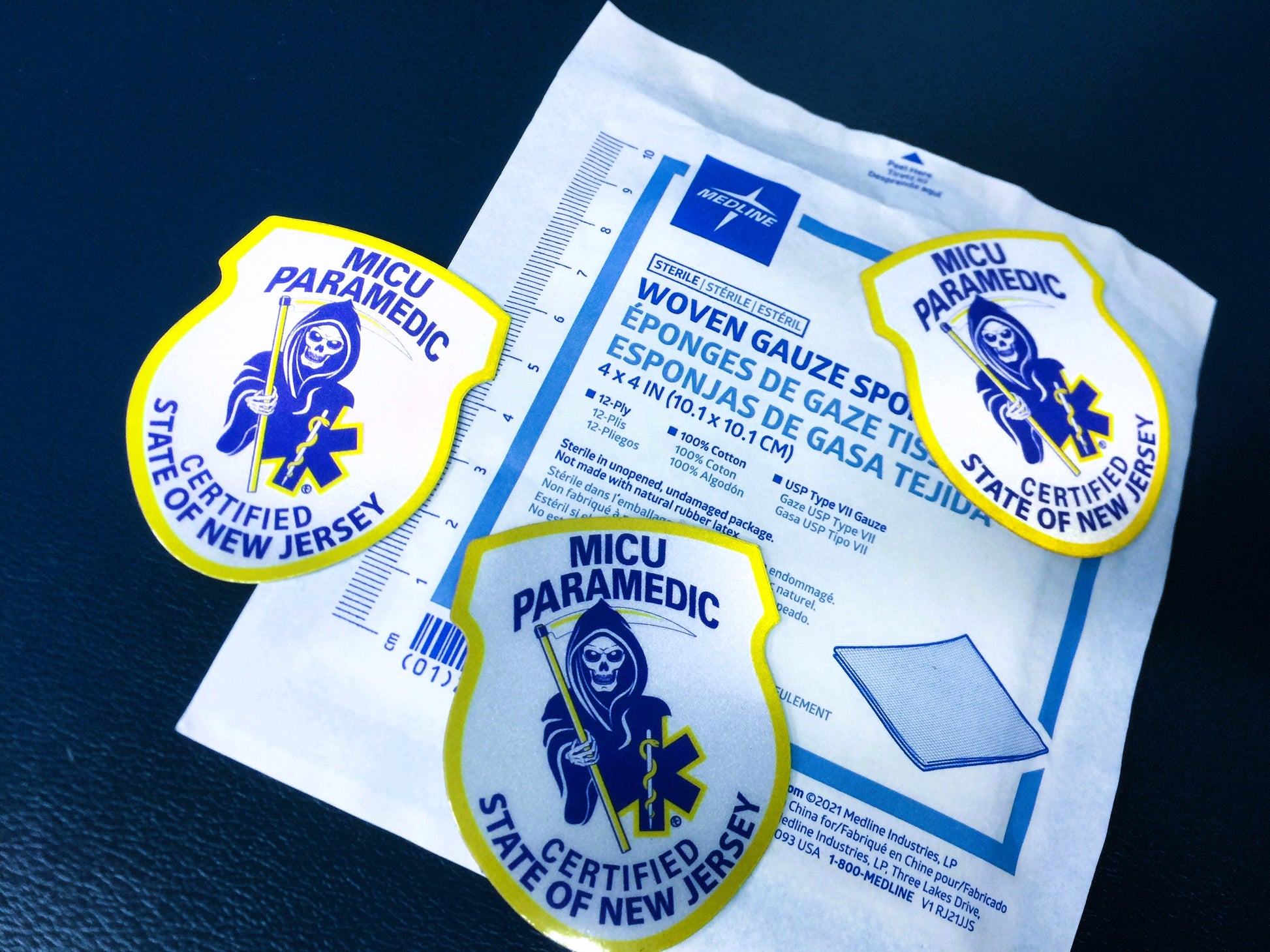 New Jersey MICU Paramedic Patch reflective stickers up against a medline 4x4 gauze package, which measures length of sticker in centimeters.