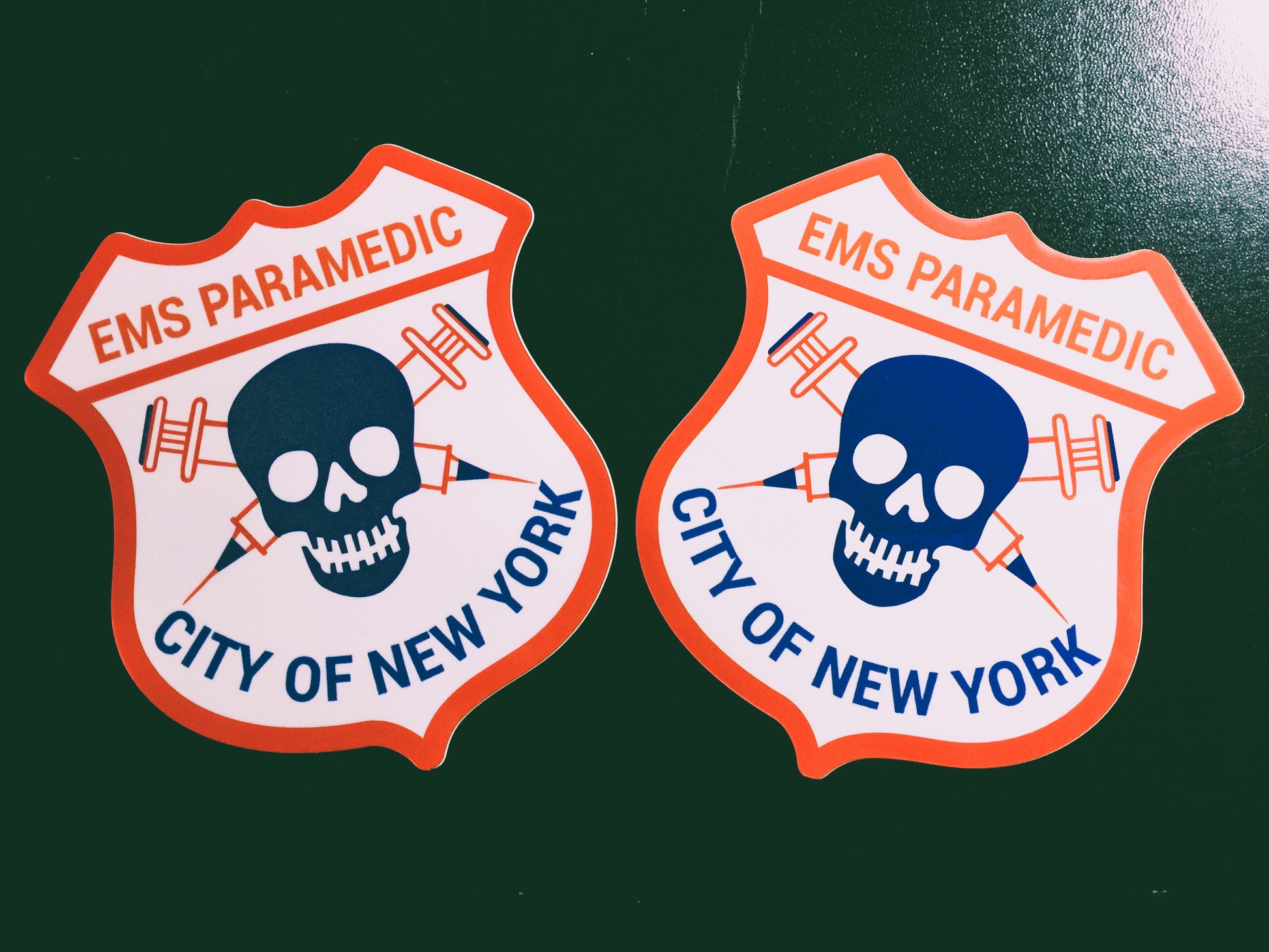 New York City Paramedic patch glossy stickers, paired up against a vintage black background.