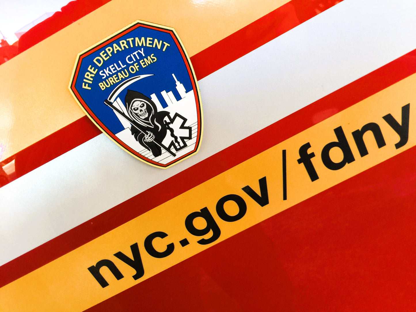 EMS patch from skell city on the side of an FDNY ambulance with web page address.