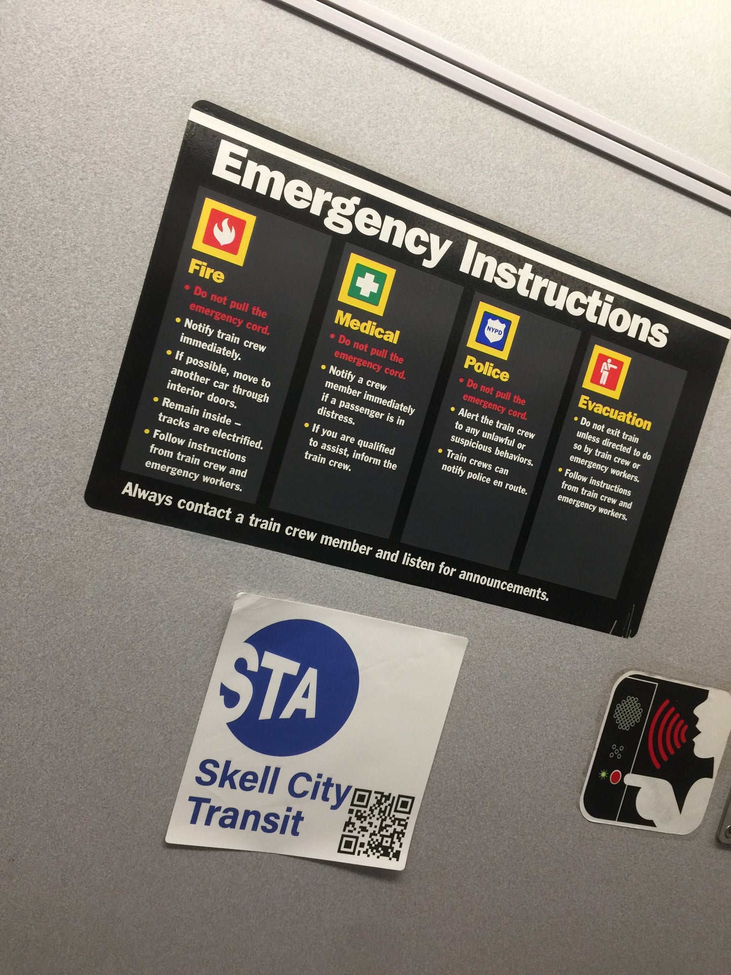 MTA station sticker next to emergency instructions sticker plaque. 